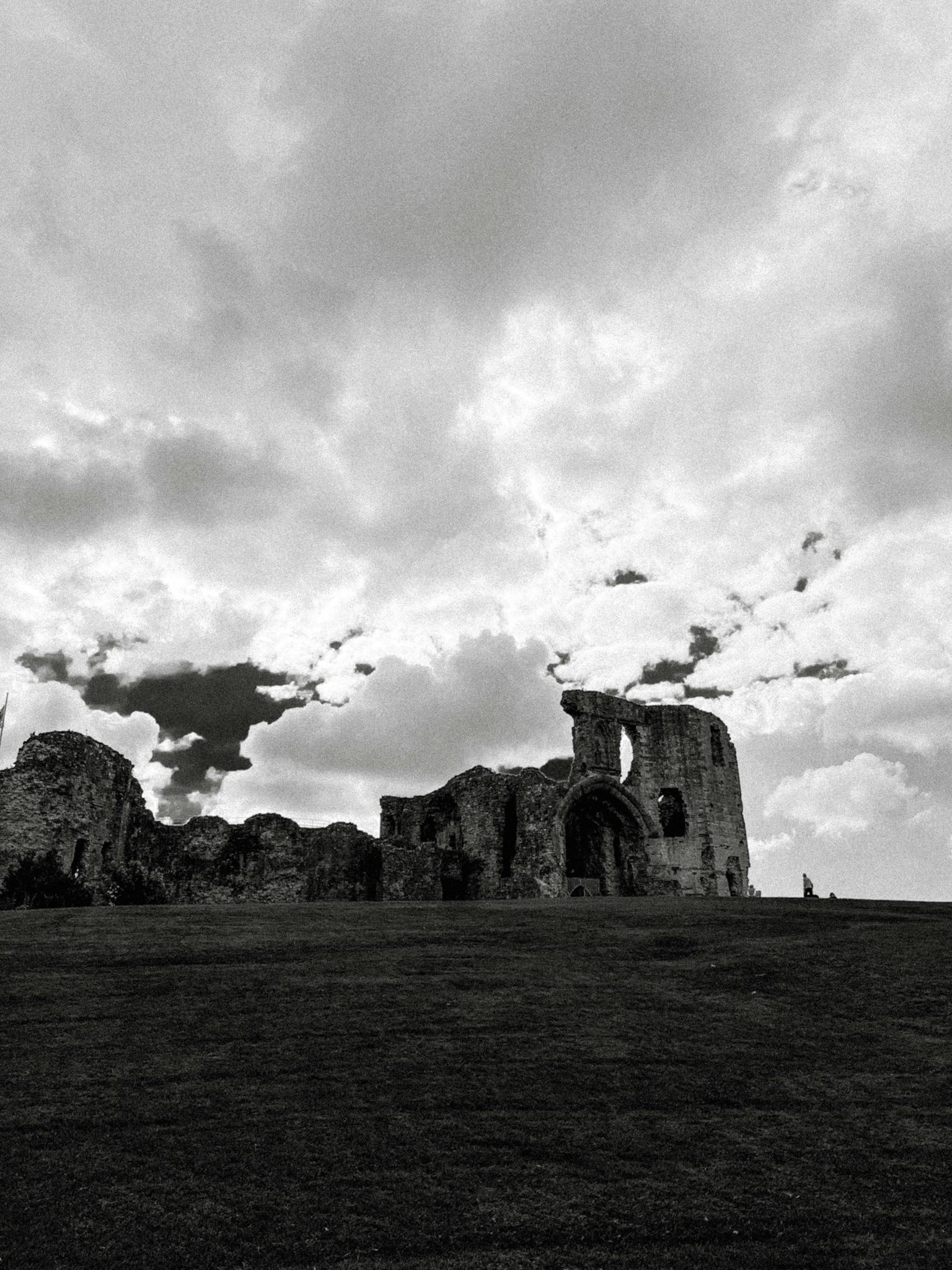 Explore the historical ruins of Denbigh Castle with dramatic skies in Wales, UK.